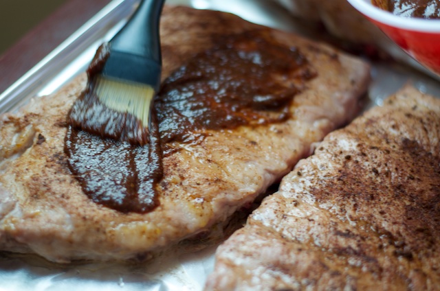brushing ribs with barbecue sauce